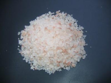 Black Tai Salt Co. 55 lbs Himalayan salt for sauna, showing large, pink, crystalline Himalayan salt block in a natural setting.