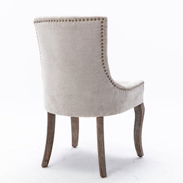 Pair of beige HouseOfZazla A&A Furniture Ultra Side Dining Chairs with thick fabric and bronze nail head detailing.