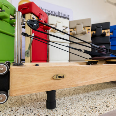Foldable Zous Pro Pilates Reformer by Personal Hour, compact Pilates machine with adjustable features and cushioned surfaces.