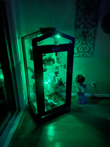 Janco greenhouse indoor/outdoor garden cabinet with glass doors and shelving for plant storage and display.