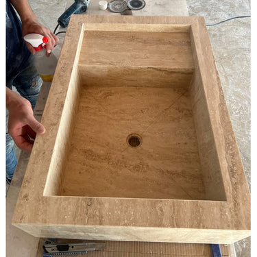 Handcrafted custom travertine sink by Luvohome, featuring a natural stone finish for kitchen use.