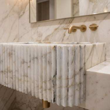 Luvohome Calacatta Gold marble wall-mounted bathroom vanity sink with fluted design, 36 inches long and 7 inches high.